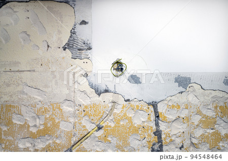 Remains of paint and plaster on a shabby old wall. Textured wall as background. Remains of paint and plaster on a shabby old wall. Textured wall as background. 94548464