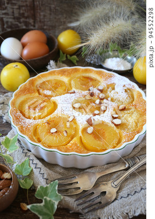 Yellow plums clafoutis (flan) with almonds, icing sugar dressing, french cuisine 94552298