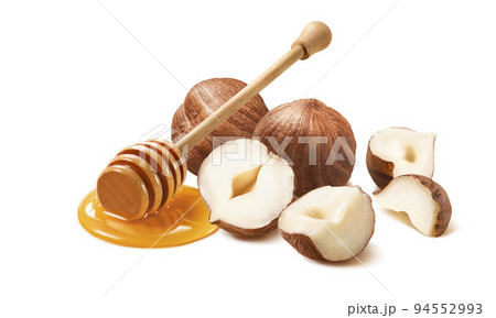 Hazelnuts and honey dipper isolated on white background Hazelnuts and honey dipper isolated on white background 94552993
