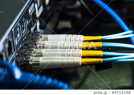 Selective focus fiber optic cables are plugged into the back panal of the server. Selective focus fiber optic cables are plugged into the back panal of the server. 94553298