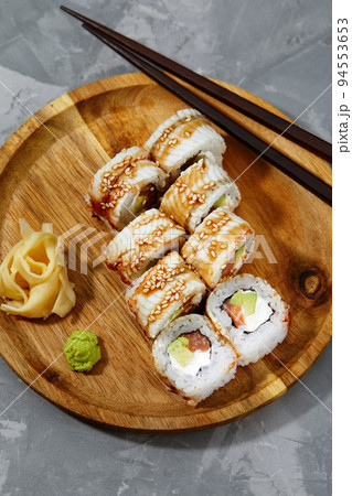 Sushi roll dragon with smoked eel and shrimp. Traditional delicious fresh sushi roll set on a black background. Sushi menu. Japanese kitchen, restaurant. Asian food 94553653