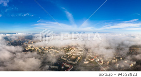 Top aerial view of fluffy white clouds over modern city with high rise buildings. Top aerial view of fluffy white clouds over modern city with high rise buildings. 94553923