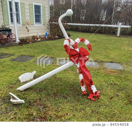 White ships anchor on a front lawn decorated for the Christmas Holiday 94554058