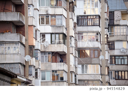 Architectural details of old high apartment building facade with many windows and balconies Architectural details of old high apartment building facade with many windows and balconies 94554829