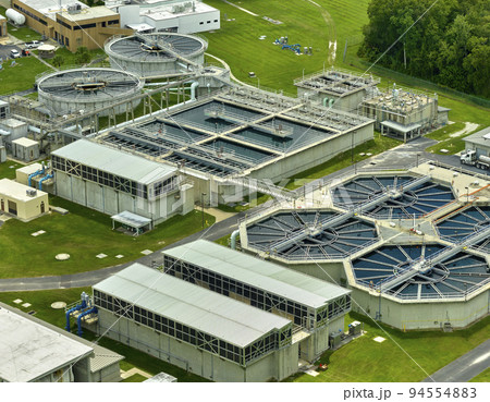Aerial view of modern water cleaning facility at urban wastewater treatment plant. Purification process of removing undesirable chemicals, suspended solids and gases from contaminated liquid Aerial view of modern water cleaning facility at urban wastewater treatment plant. Purification process of removing undesirable chemicals, suspended solids and gases from contaminated liquid 94554883