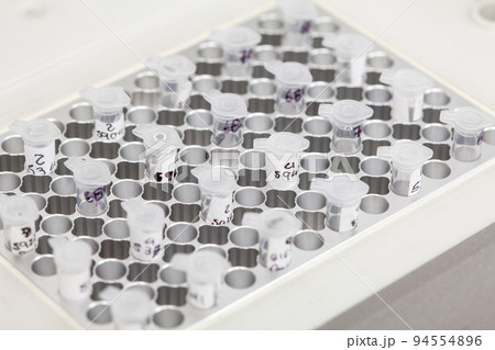 Closeup of test tubes at a thermal cycler block in a molecular biology laboratory. Polymerase chain reaction technique. PCR technique 94554896