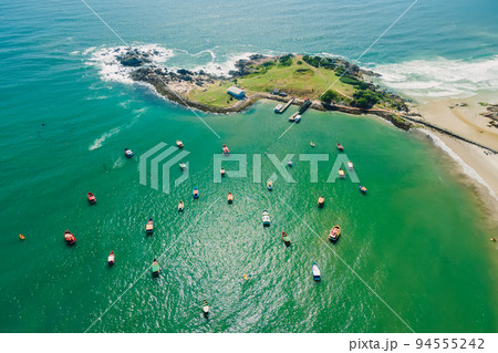 Coastline with rocky island, beach and ocean with waves. Aerial view of Ponta das Campanhas in Floripa Coastline with rocky island, beach and ocean with waves. Aerial view of Ponta das Campanhas in Floripa 94555242