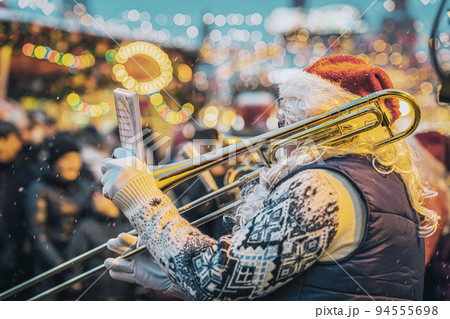 Jazz musician playing trumpet in Santa Claus costume, Christmas performance 94555698