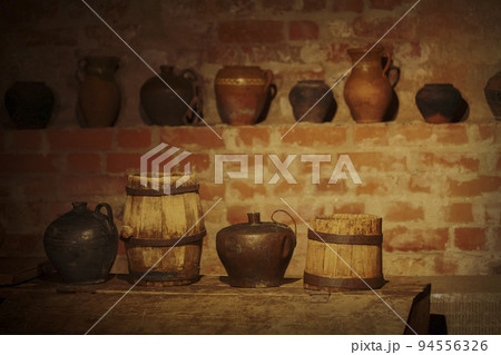 Vintage crockery, wooden barrels in an old cellar. Vintage crockery, wooden barrels in an old cellar. 94556326