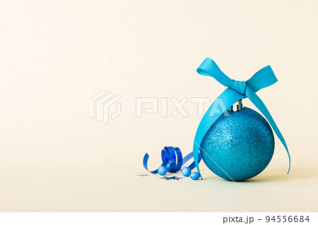 Christmas ball on colored background. decoration bauble with ribbon bow with copy space 94556684