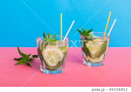 Mojito summer refreshing cocktail with ice and mint. mojito cocktail with lime, lemon and mint in a tall glass with a stick Mojito summer refreshing cocktail with ice and mint. mojito cocktail with lime, lemon and mint in a tall glass with a stick 94556852