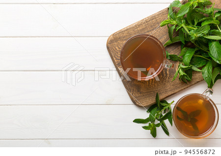 Cup of mint tea on table background. Green tea with fresh mint top view with copy space 94556872