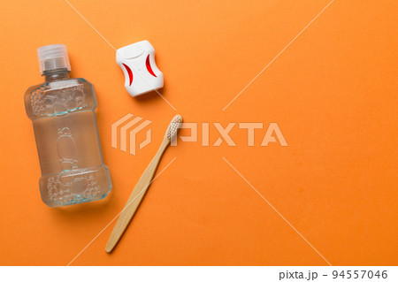 Mouthwash and other oral hygiene products on colored table top view with copy space. Flat lay. Dental hygiene. Oral care products and space for text on light background. concept 94557046
