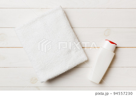 Cosmetic shampoo bottle mockup with towels on a colored table. Bathroom background, toilet accessories for hand and body care 94557230