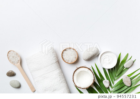 Coconut with jars of coconut oil and cosmetic cream on colored background. Top view. Free space for your text. Natural spa coconut cosmetics and organic treatment concept Coconut Spa composition Coconut with jars of coconut oil and cosmetic cream on colored background. Top view. Free space for your text. Natural spa coconut cosmetics and organic treatment concept Coconut Spa composition 94557231