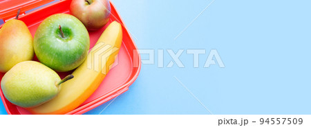 Banner with lunch box with fruits. Useful snack. Top view. Copy space. Blue background. Place for text. 94557509