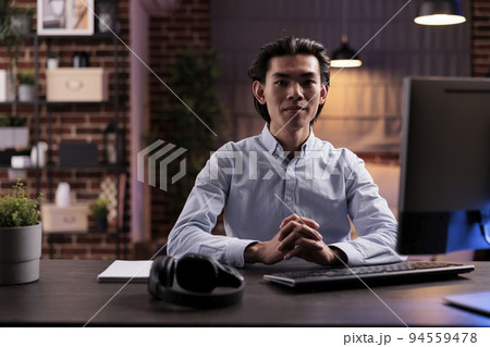 Asian man working remotely on computer, using online research information on website to plan business report. Doing remote work on startup company network, sending email to manager. Asian man working remotely on computer, using online research information on website to plan business report. Doing remote work on startup company network, sending email to manager. 94559478
