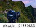 谷川岳・夜明けの様子を撮影する一眼レフカメラ 94559833