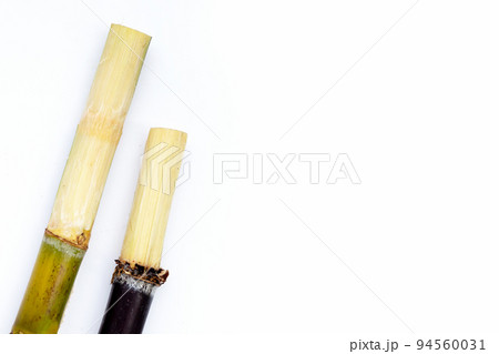 Sugar cane with brown sugar on white background 94560031