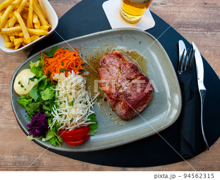 Traditional Belgian grilled pork steak varkens cote de los with vegetables Traditional Belgian grilled pork steak varkens cote de los with vegetables 94562315