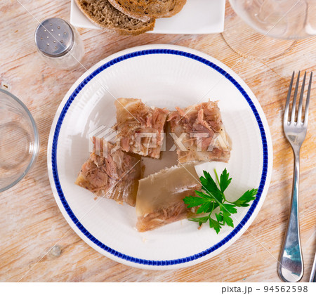 Kholodets served on table with parsley sprig Kholodets served on table with parsley sprig 94562598
