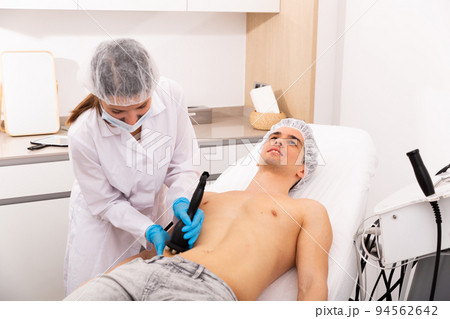 Man getting body ultrasound lifting procedure Man getting body ultrasound lifting procedure 94562642