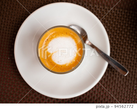 Cortado served with plate with spoon 94562772