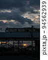（鉄道の風景）曇天の日没風景、高架を走る通勤電車 94562939
