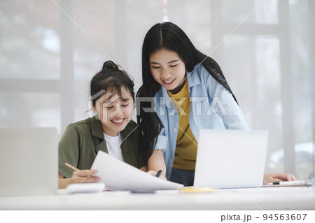 Young asian college university students studying learning discuss working on computer. 94563607