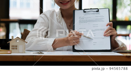 Business woman or broker checking contract agreement paper with customer to sign contract. Real Estate and Agreement concept 94565788