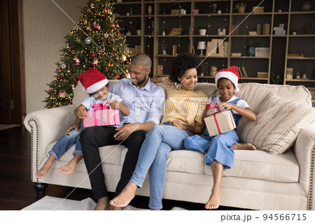 Happy millennial parents giving Christmas gifts to kids 94566715