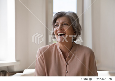 Cheerful excited mature woman looking away, laughing Cheerful excited mature woman looking away, laughing 94567170