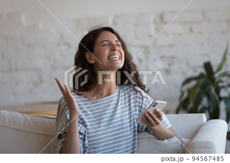 Overjoyed woman holds smartphone relish moment of lottery win Overjoyed woman holds smartphone relish moment of lottery win 94567485