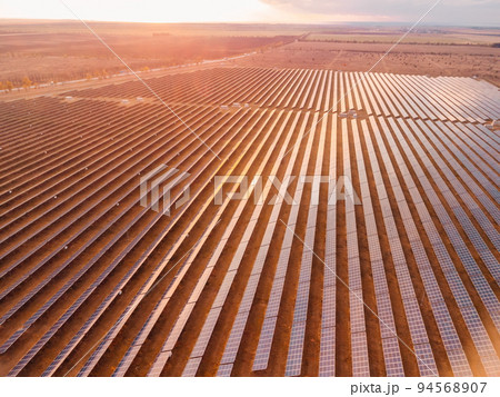Aerial top view of a solar panels power plant. Photovoltaic solar panels at sunrise and sunset in countryside from above. Modern technology, climate care, earth saving, renewable energy concept. 94568907