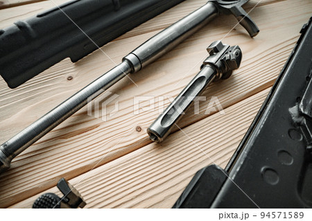 Shotgun parts on the wooden table background. Shotgun parts on the wooden table background. 94571589