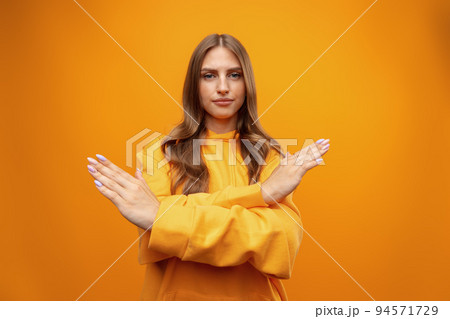 Portrait of attractive girl showing reject sign with crossed arms in studio 94571729