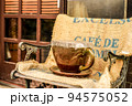 椅子に置かれた大きいコーヒーカップ 94575052