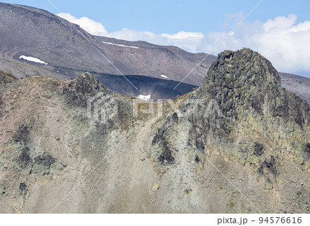tourists on a camel extrusion on the Kamchatka peninsula near Avachinsky and Koryaksky volcano 94576616