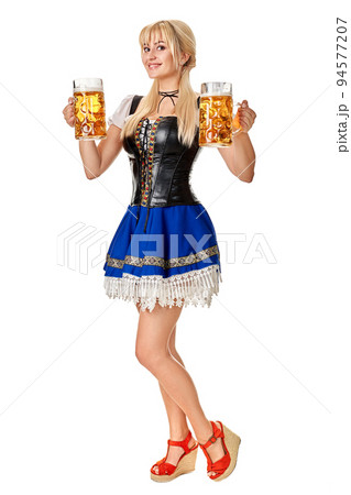 Full length portrait of a blond woman with traditional costume holding beer glasses isolated on white background. 94577207