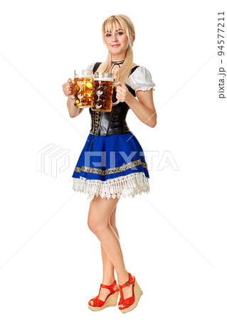 Full length portrait of a blond woman with traditional costume holding beer glasses isolated on white background. 94577211