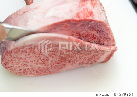 まな板で牛ブロック肉を切る 94579354