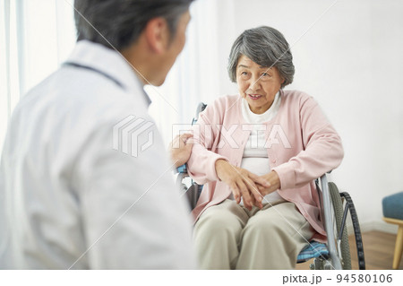 車椅子に座るシニアの女性と男性医師 94580106