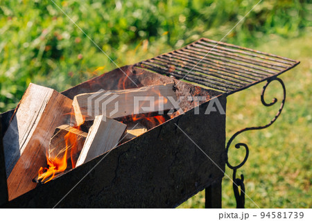 charcoal grill outside, burning wood, barbecue preparations charcoal grill outside, burning wood, barbecue preparations 94581739