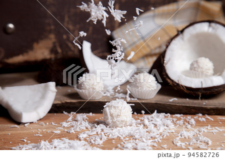 Close up of white candies and coconut with white pulp, coconut chip on wooden background.. 94582726