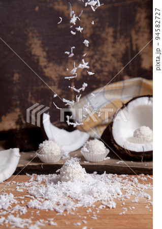 Close up of white candies and coconut with white pulp, coconut chip on wooden background.. 94582727