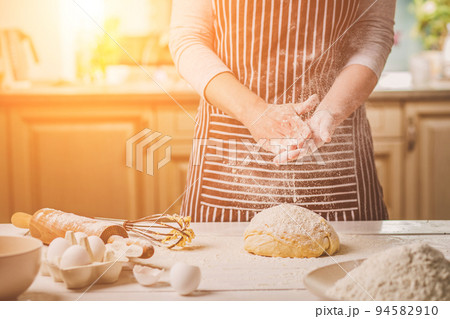 Woman slap his hands above dough closeup. Baker finishing his bakery, shake flour from his hands, free space for text. 94582910