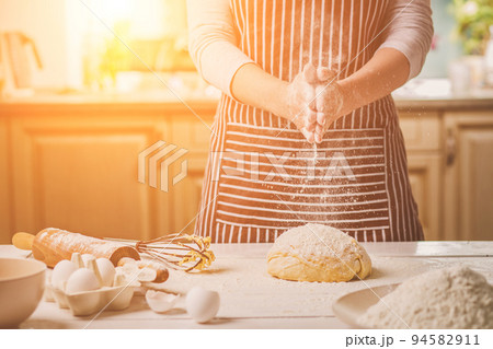 Woman slap his hands above dough closeup. Baker finishing his bakery, shake flour from his hands, free space for text. 94582911