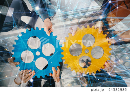 Business team connect pieces of gears like a teamwork and partners Business team connect pieces of gears like a teamwork and partners 94582986