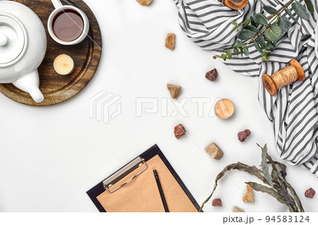 Opened diary with pen on the table near hot cup of black tea 94583124
