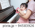 アップライトピアノを弾く1歳の女の子とママ 94583926
